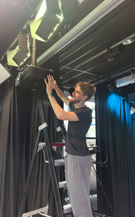 Wessel stelt de projectieapparatuur af tijdens het project van De Rode Ruiters.